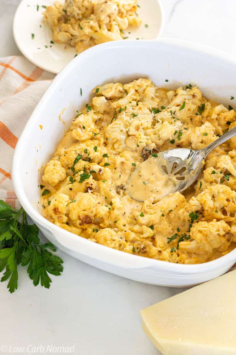 White dish filled with cheesy cauliflower and cheese