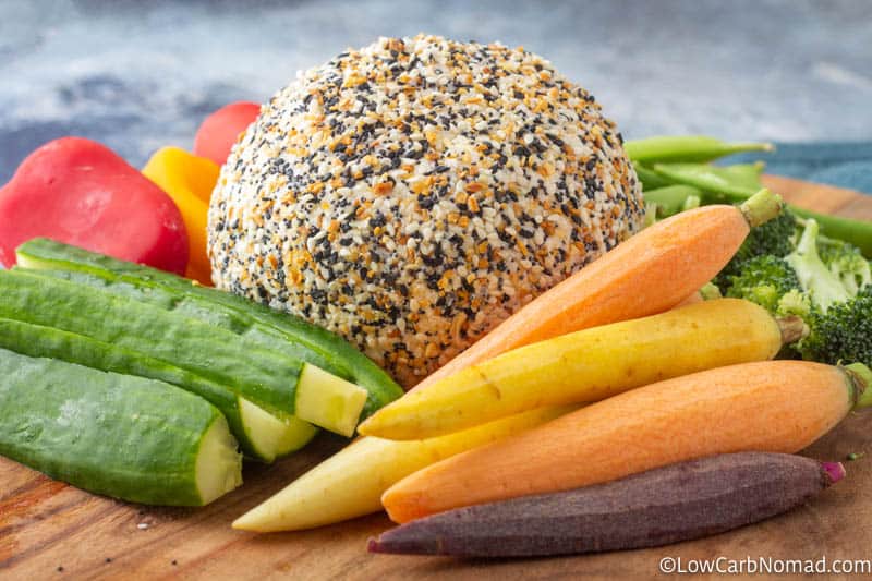 Everything bagel Cheese ball on a platter with carrots, cucumbers, peppers and sugar snap peas