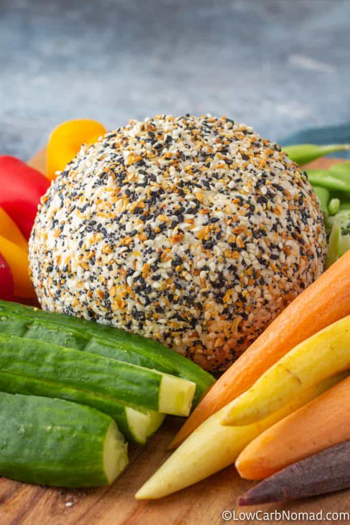 Cheese ball on a platter with carrots, cucumbers, peppers and sugar snap peas