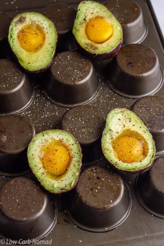 avocados with eggs on an upside down muffin pan to bake in the oven