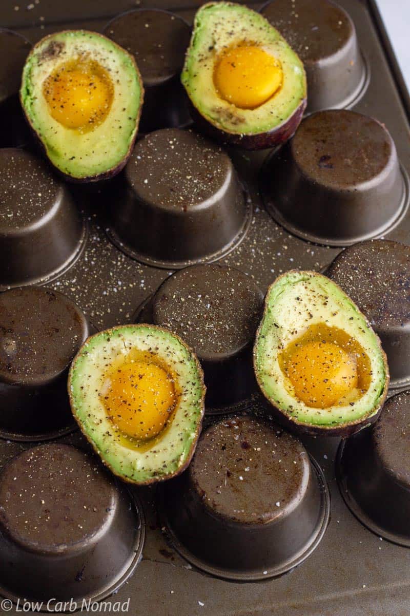 avocados with eggs on an upside down muffin pan to bake in the oven