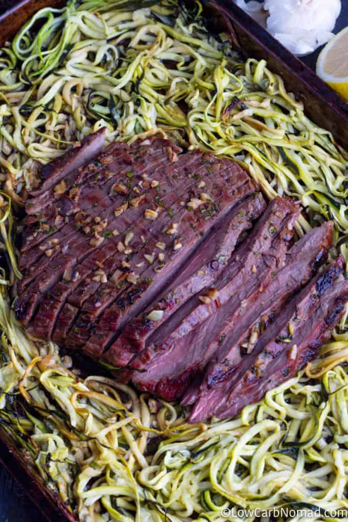 cooked sheet pan oven baked steak recipe with zucchini noodles on a baking sheet