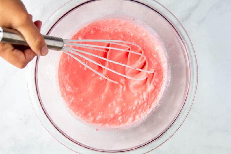 heavy cream being mixed with a whisk to water and jello mixture