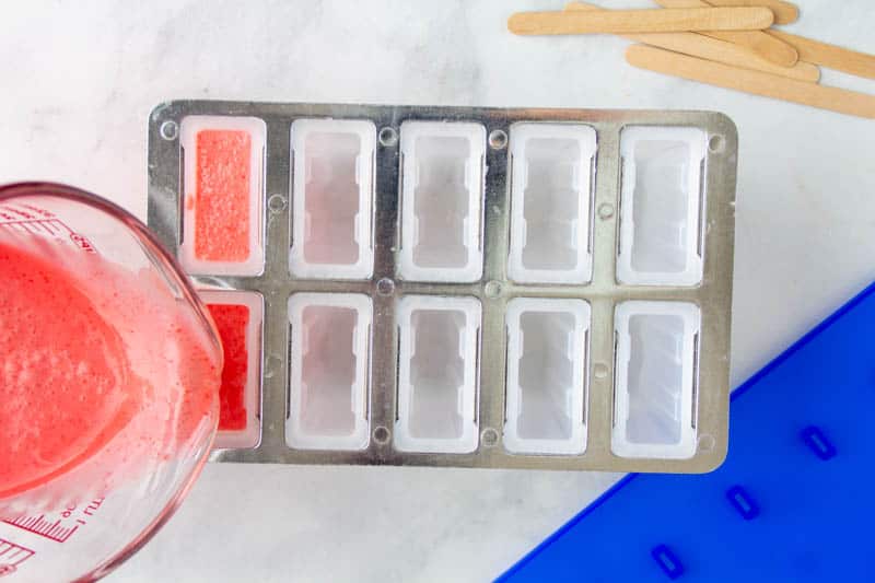 keto popsicle mixture being poured into popsicle mold