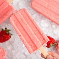Hand holding a strawberry keto popsicle