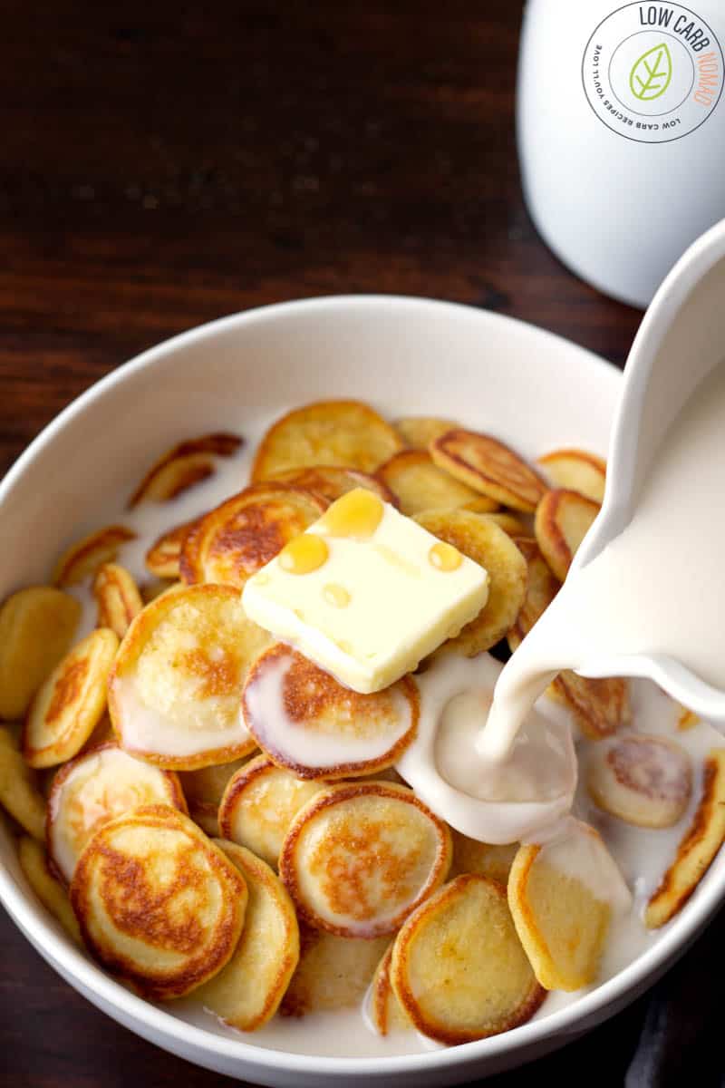 Low carb mini pancakes in a bowl with almond milk and butter