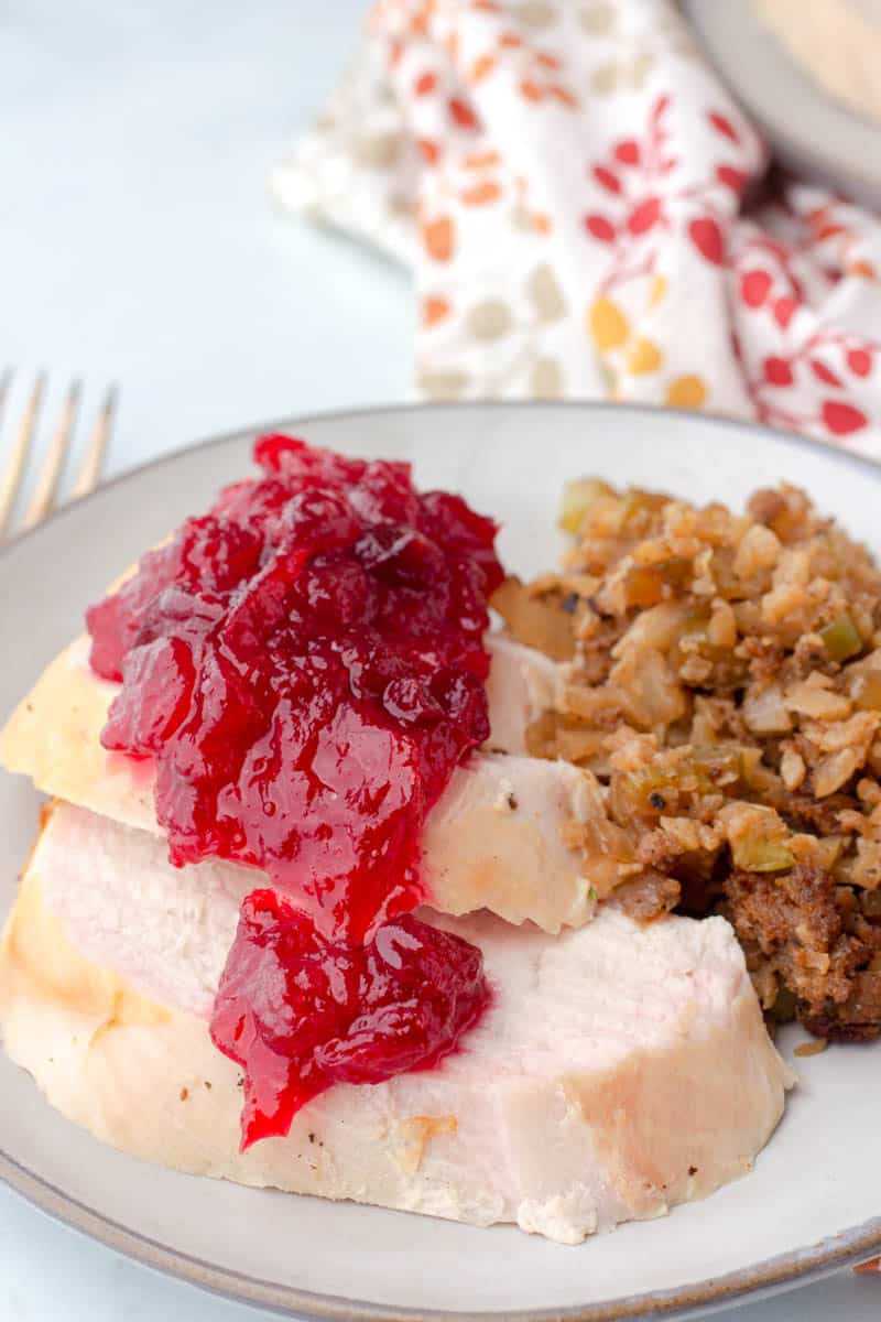 keto cranberry sauce poured on top of fresh made turkey and keto stuffing on a plate