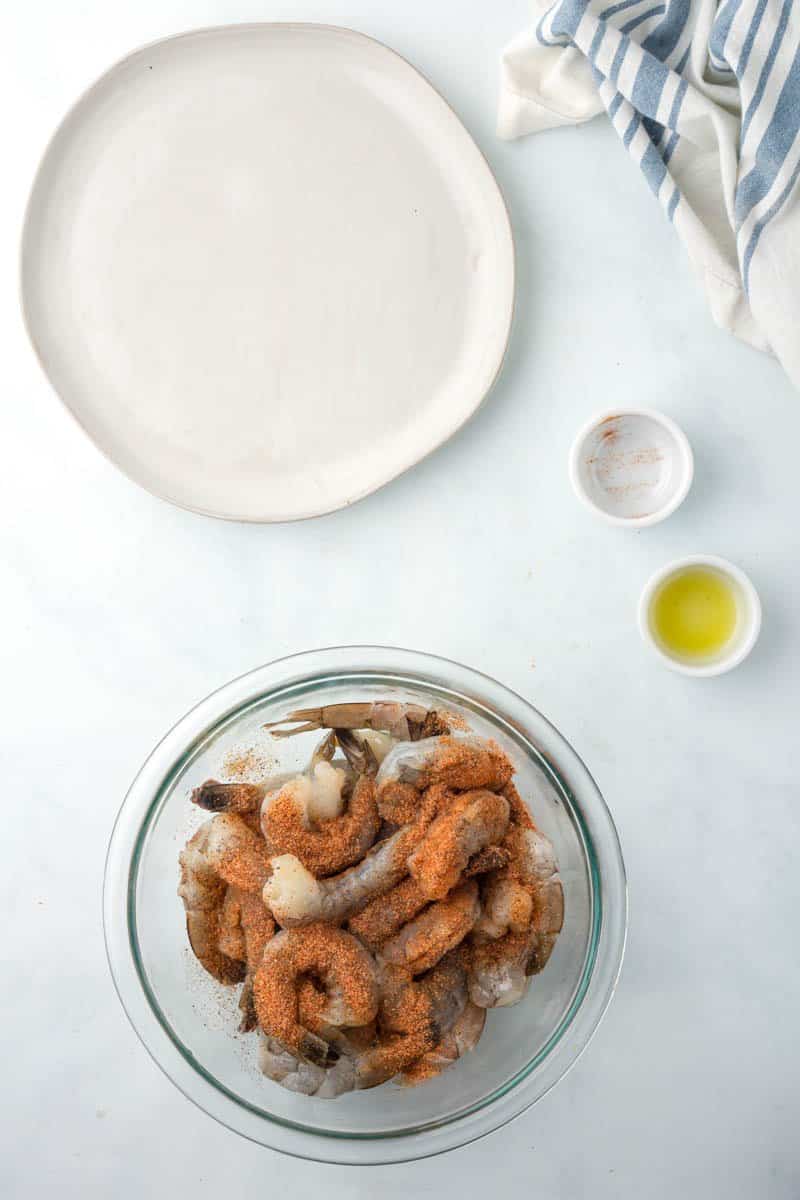 raw shrimp in a bowl with cajun seasoning