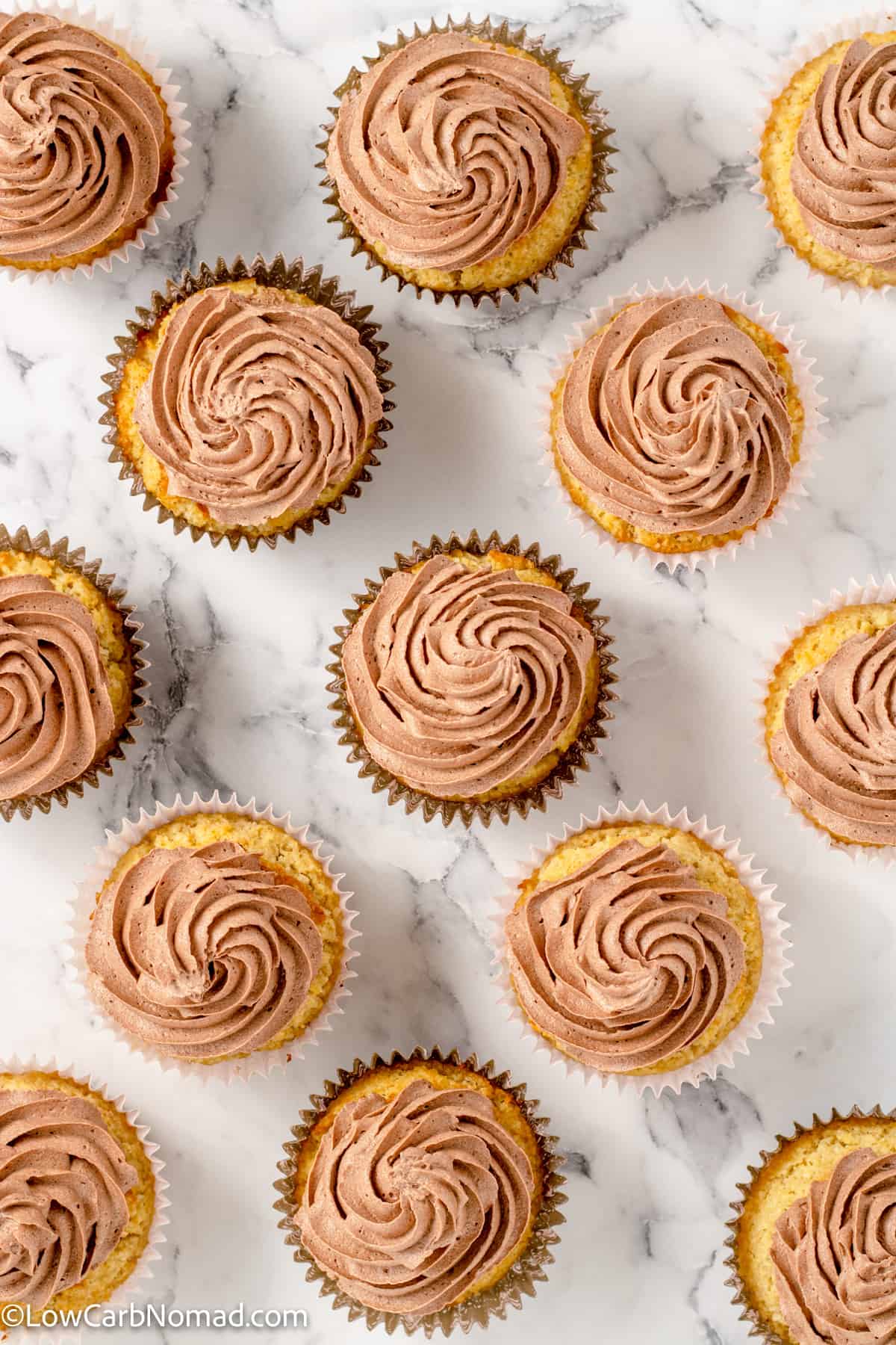 overhead photo of Keto Vanilla Cupcakes topped with chocolate keto frosting
