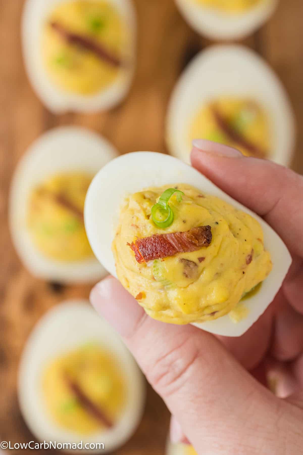 hand holding a Bacon Deviled Egg