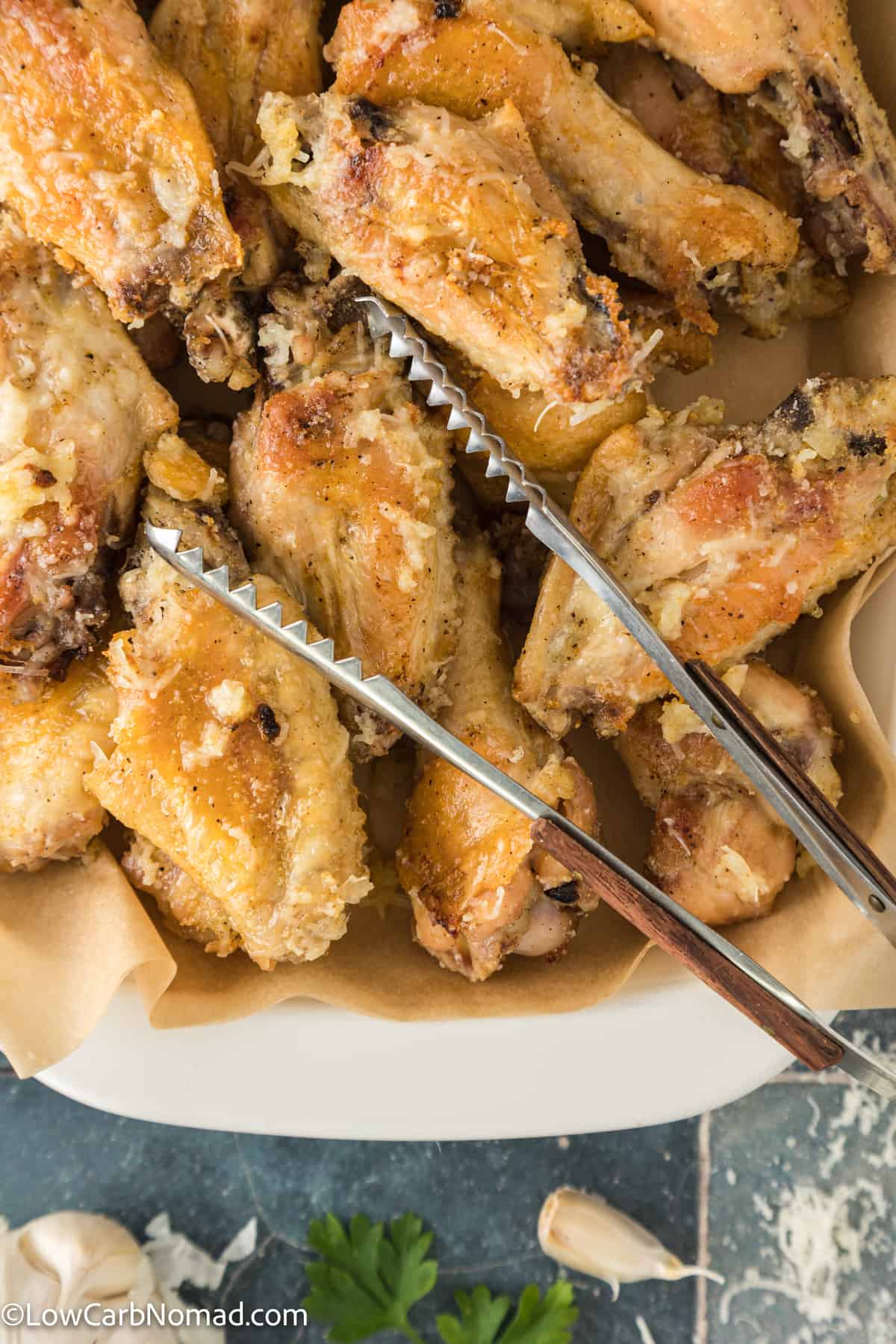 close up photo of Garlic Parmesan Chicken wings in a baking dish